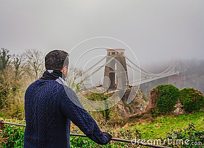 Man in focus looking at famous Clifton bridge in Bristol Editorial Stock Photo