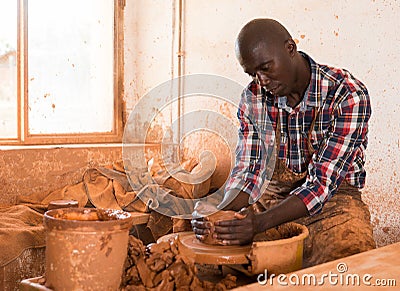 Man focused on work on pottery wheel Stock Photo