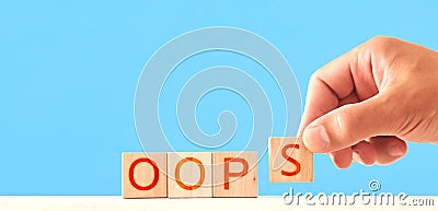 a man folds an inscription from wooden blocks oops. Stock Photo