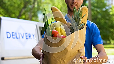 Man from food delivery holding full bag of fresh goods, online store service Stock Photo