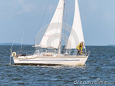 Man on foredeck of sailboat sailing on IJsselmeer lake, Netherlands Editorial Stock Photo