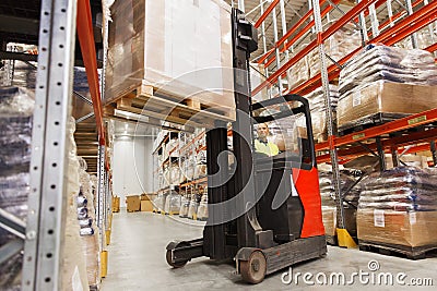 Man on forklift loading cargo at warehouse Stock Photo