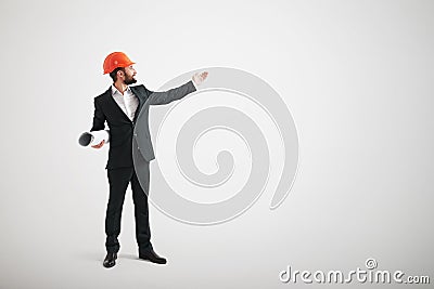 Man in formal wear and a construction helmet point his hand toward Stock Photo