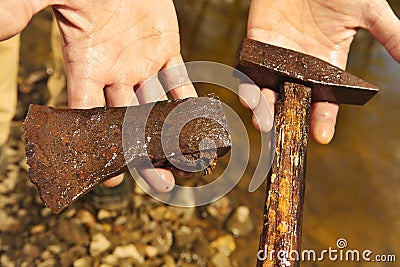 Exploring of river with magnet on rope and finding of hammer and axe Stock Photo