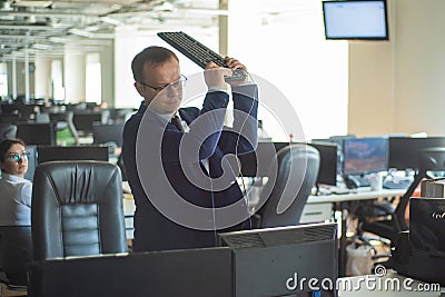 A man freaks out and gets depressed from a mistake and breaks the keyboard on the monitor. The male manager is angry and Stock Photo