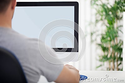Man in front of computer, back view Stock Photo