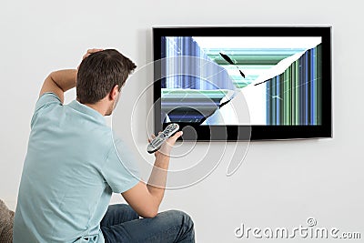 Man In Front Of Television Showing Distorted Screen Stock Photo