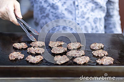 Man frying small round kebabs. Stock Photo
