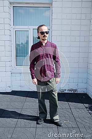 Man full body portrait. Street style. Cheerful bearded hipster man in black glasses Stock Photo