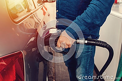 man at the gas station filling the tank of his car with diesel to the top level before a long journey Stock Photo