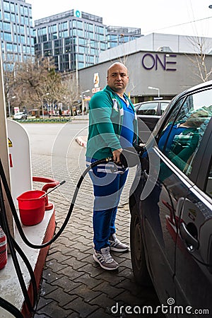 Man at gas station filling up the car with petrol in Bucharest, Romania, 2020 Editorial Stock Photo