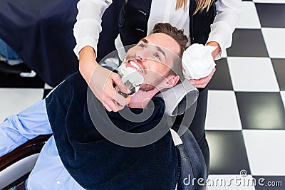 Man getting beard shave in barber salon Stock Photo