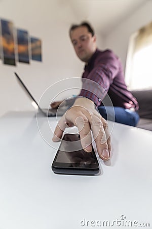 Man getting a call and taking his mobile phone Stock Photo