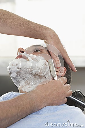 Man Getting Shave At Barbershop Stock Photo