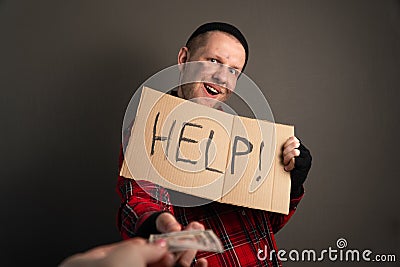Man gives alms to the homeless. unemployed takes money for a living. cardboard begging Stock Photo