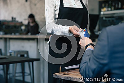 Man giving credit card to waiter in cafe Stock Photo