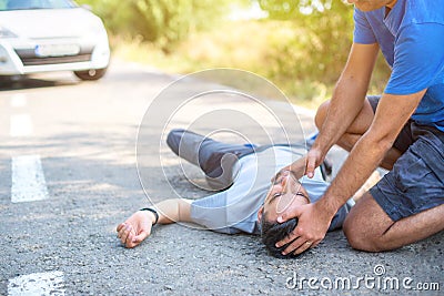 Man giving first aid in car accident Stock Photo