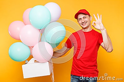 Man giving food order cake box on yellow background. Male employee courier in red cap t-shirt hold colorful air Stock Photo