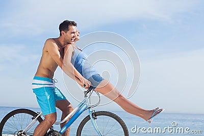 Man giving girlfriend a lift on his crossbar Stock Photo