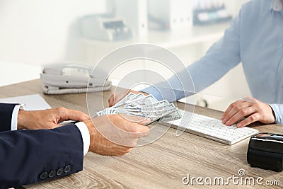 Man giving money to teller at cash department window Stock Photo