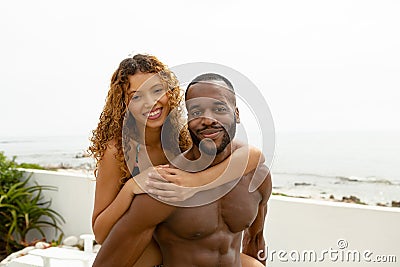 Man giving piggyback ride to woman near swimming pool at the backyard of home Stock Photo