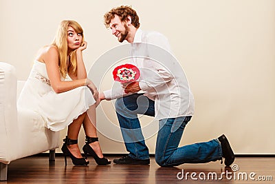 Man giving unhappy woman candy bunch flowers. Stock Photo