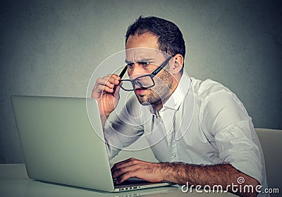 Man with glasses having eyesight problems confused with laptop software Stock Photo