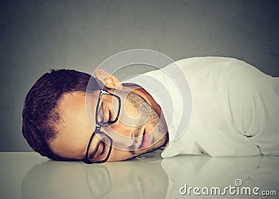 Man with glasses sleeping on desk Stock Photo