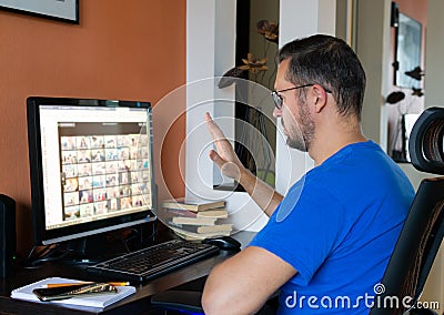 Man with glasses is talking on a video chat on a computer, conference calls at home Stock Photo
