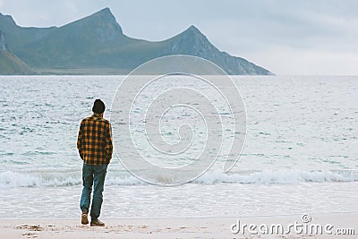 Man globetrotter walking on Haukland beach in Norway Lofoten islands adventure travel lifestyle Stock Photo