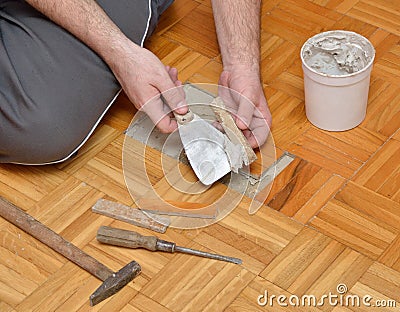 Man is Gluing Wooden Floor Stock Photo