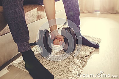 A man goes in for sports at home with dumbbells Stock Photo