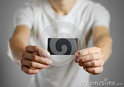 A man in a gray t-shirt holding blank clear black of the sheet. Stock Photo