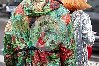Man with green and red decorated jacket and woman with silver sequin dress before Max Mara fashion show, Editorial Stock Photo