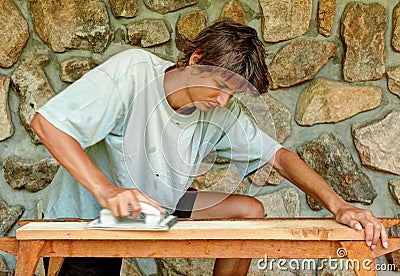 Man grinding wooden plank Stock Photo
