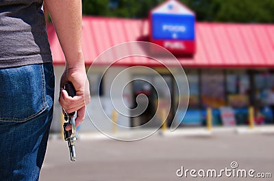 Man with gun ready to rob a convenience store Stock Photo