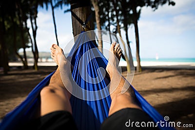 Man in Hammock Faces Beach with Happy Feet Stock Photo