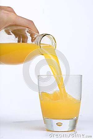 Man Hand, Bottle pouring Orange juice over glass Stock Photo