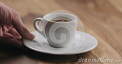 Man hand bring cup of fresh espresso on wood table Stock Photo