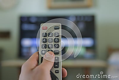 Man hand while browse smart tv app,zapping channels on leisure time,tech lifestyle Stock Photo