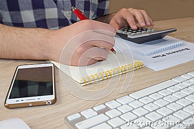 Man hand with calculator at workplace office. A businessman doing some paperwork using his calculator Stock Photo