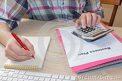 Man hand with calculator at workplace office. A businessman doing some paperwork using his calculator Stock Photo