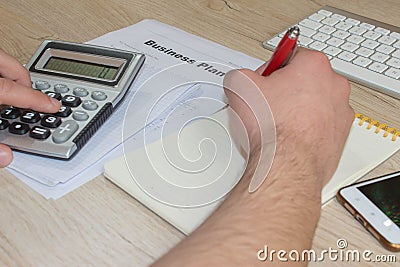 Man hand with calculator at workplace office. A businessman doing some paperwork using his calculator Stock Photo