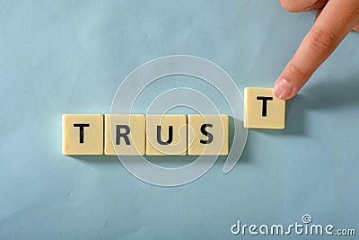 Man hand complete word Trust on plastic block Stock Photo