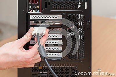 Man hand connecting the DVI cable for monitor to computer PC. Stock Photo