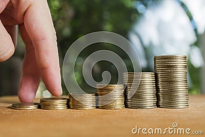 Man hand finger walking on coins stairs. Concept Steps of success achieving or stairs to reach success your goal,target, finance, Stock Photo