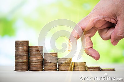 man hand finger walking to the top of growing up stack to coins Stock Photo