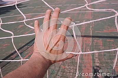 Man hand grabbing the rope net on the street Stock Photo