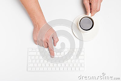 A man hand hold a wireless keyboard and coffee cup isolated on white Stock Photo