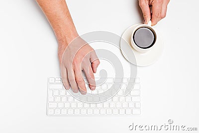 A man hand hold a wireless keyboard and coffee cup on white Stock Photo